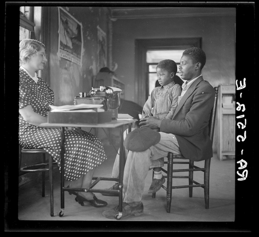 A rehabilitation client with his son repays a government loan, Smithfield, N.C., October 1936