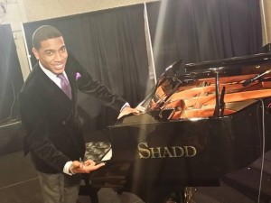 Pianist Christian Sands stands with a Shadd Piano at the Mid-Atlantic Jazz Festival in 2014.
